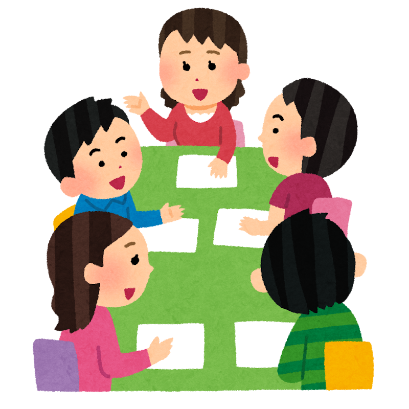 机を囲んで付箋を貼りながら議論するグループ